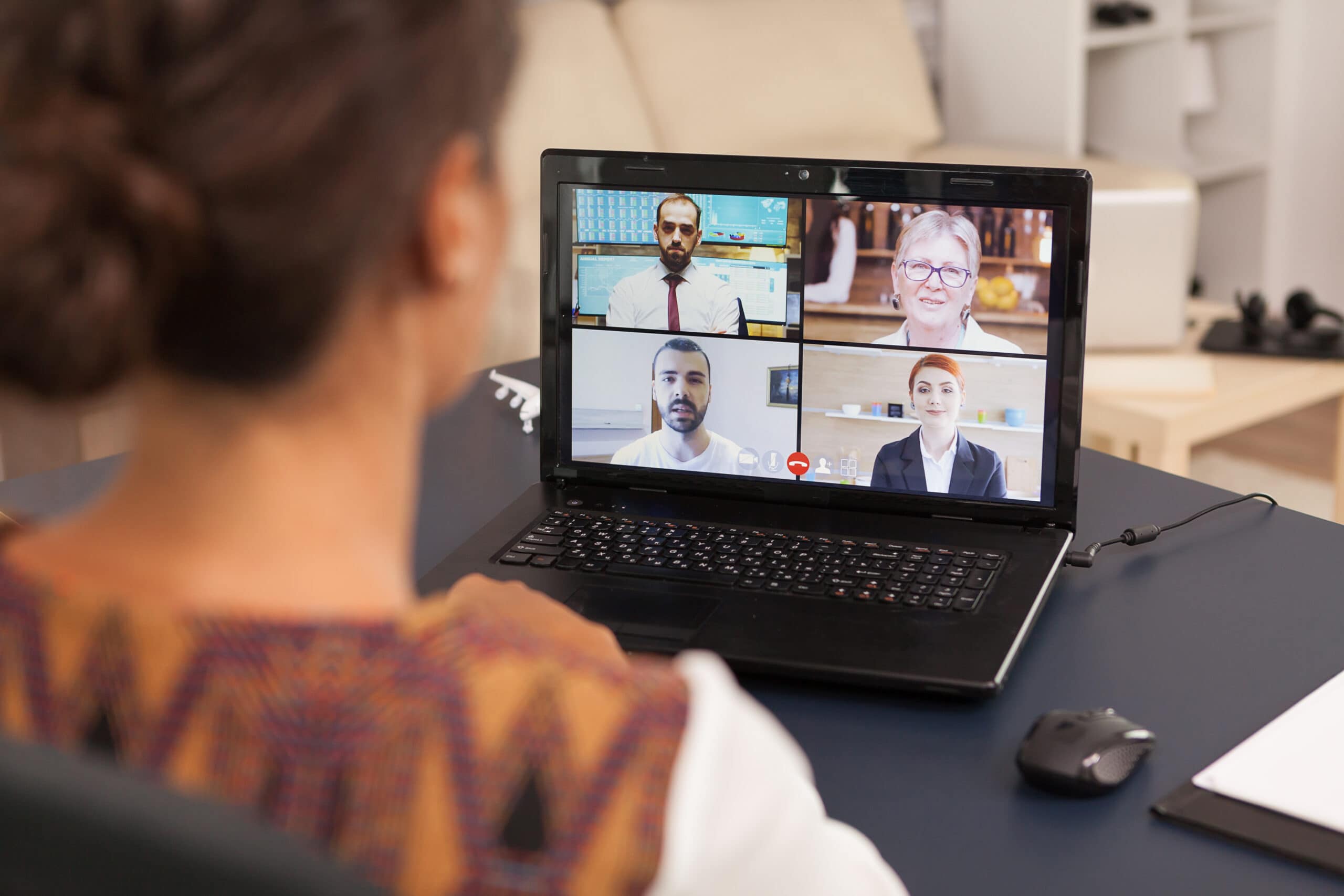 A woman talks with colleagues on a video call, using her tablet.