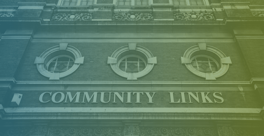 A close-up photograph of a brick building with ornate windows, with a sign for "Community Links" above the doors.