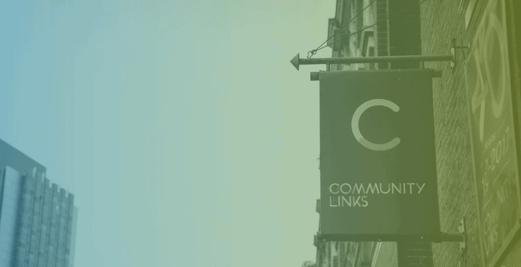 A hanging sign on the side of a building which reads "Community Links"