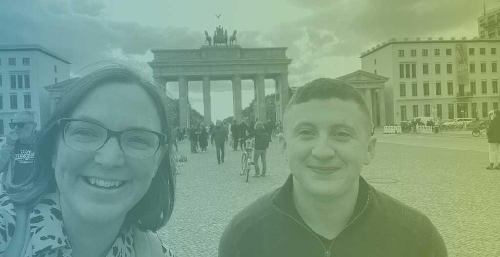 Hannah and Ralph smile in front of the Brandenburg Gate in Berlin.