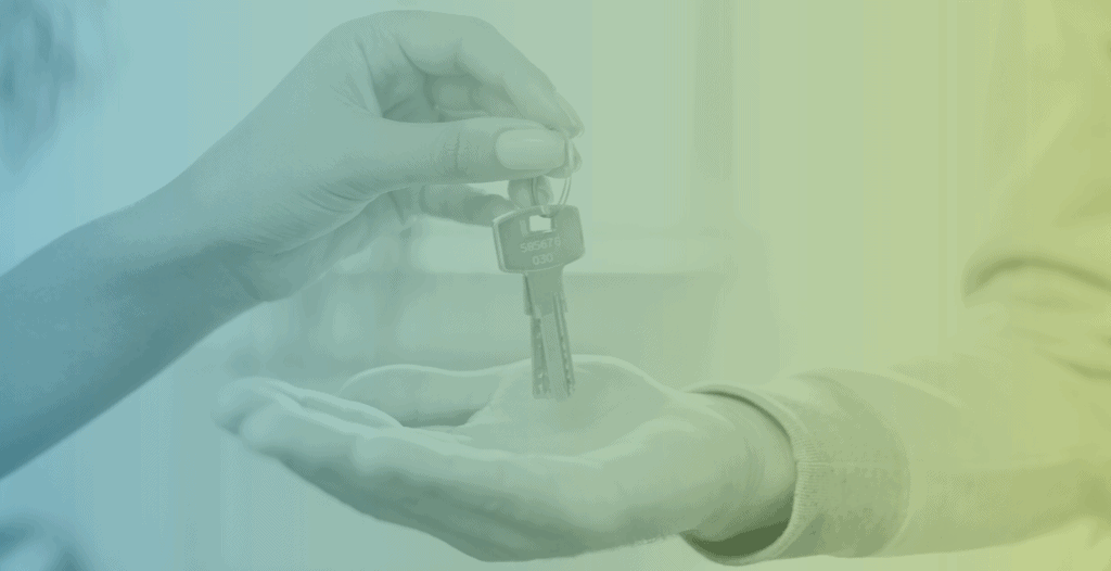 Close-up of someone placing a house key into the hand of another person.
