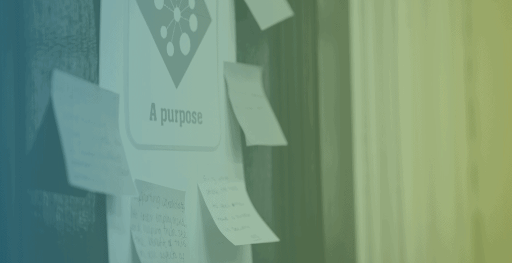 A poster stuck on the wall reads "A purpose". Around it are post-it notes where people have written what "purpose" means to them. None of the post-it notes are legible.